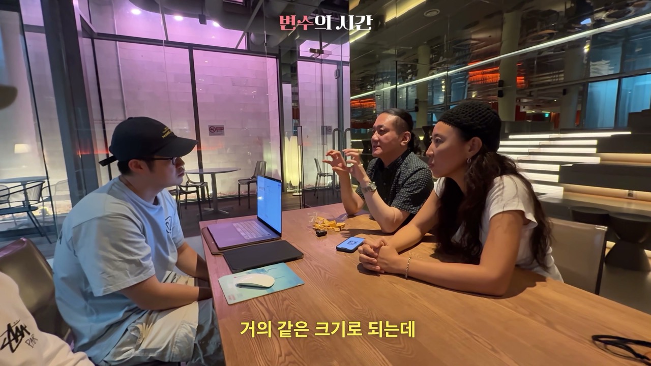 장면 9 — 회의 테이블에서 여러 사람과 변수를 다루는 장면